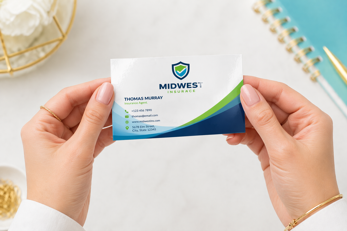 Person holding a business card with Midwest Insurance logo on a light background