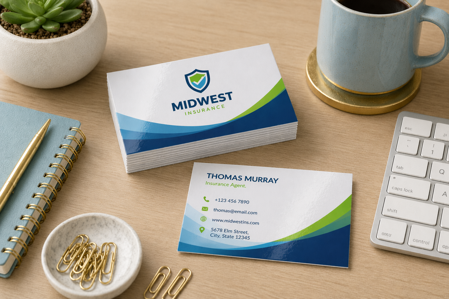 Business cards with 'Midwest' branding on a desk with a coffee cup, notebook, and keyboard.