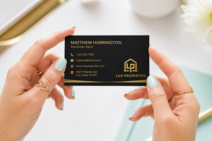 Person holding a black business card with gold text and Lux Propretes logo.